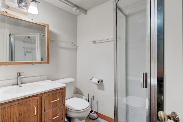 bathroom with vanity, toilet, and a shower stall