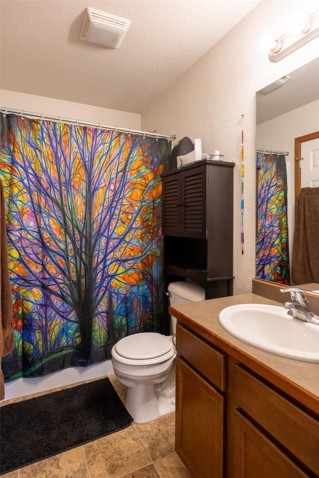 bathroom featuring visible vents, toilet, a textured ceiling, and a textured wall