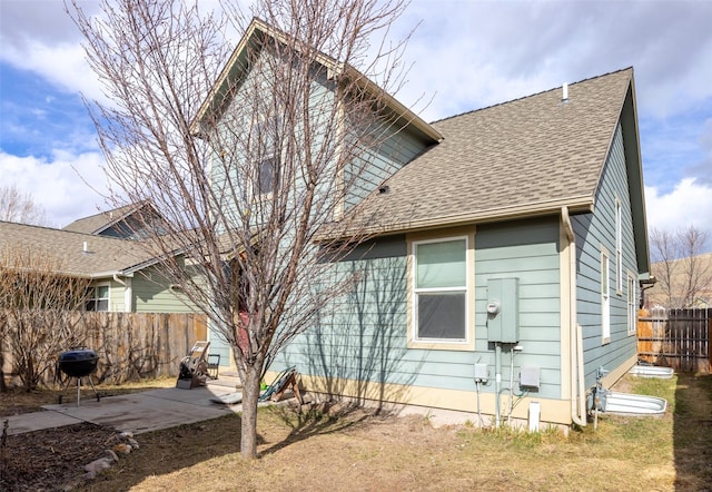 back of property featuring a patio area, fence, and roof with shingles