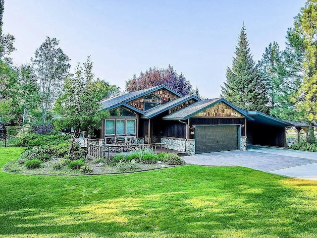 view of front facade featuring stone siding, concrete driveway, a front yard, a garage, and an attached carport