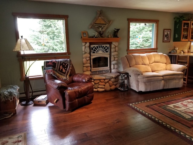 living area featuring a baseboard heating unit, a fireplace, and wood-type flooring