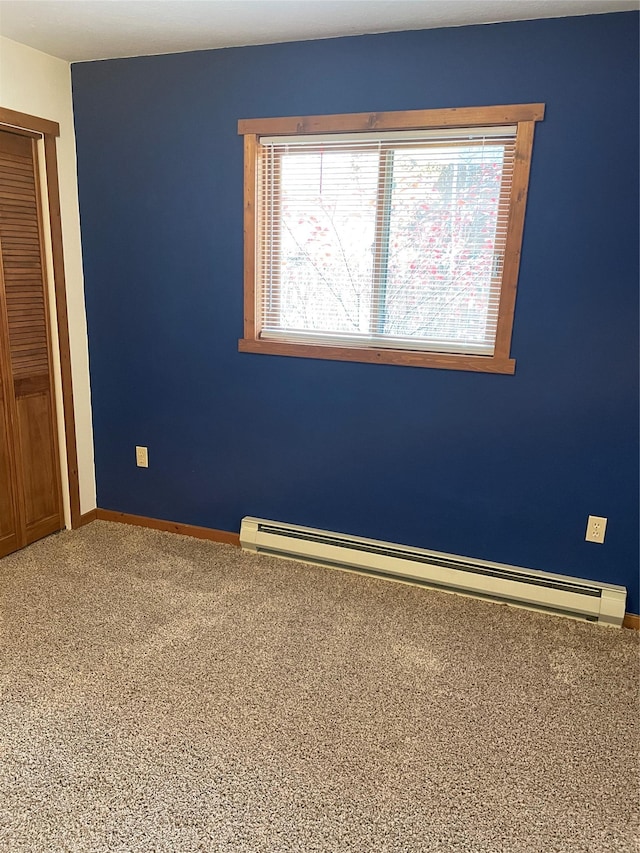 spare room with baseboards, baseboard heating, and carpet flooring