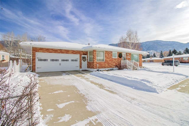 ranch-style home with brick siding, an attached garage, and driveway