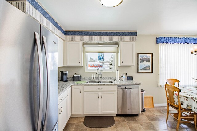 3790 Continental Dr, Butte, MT 59701 - kitchen featuring light stone counters, a sink, white cabinetry, stainless steel appliances, and baseboards
