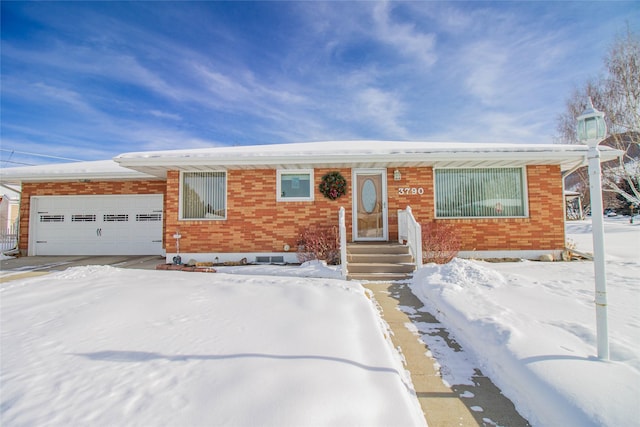 view of front of home featuring concrete driveway, brick siding, and a garage