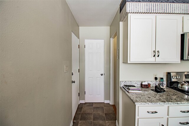 3790 Continental Dr, Butte, MT 59701 - kitchen with baseboards, stainless steel microwave, white cabinets, and light stone counters