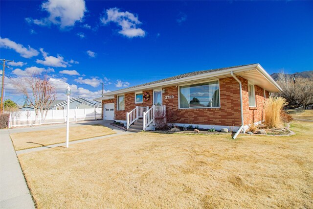3790 Continental Dr, Butte, MT 59701 - ranch-style home with driveway, a front yard, an attached garage, fence, and brick siding