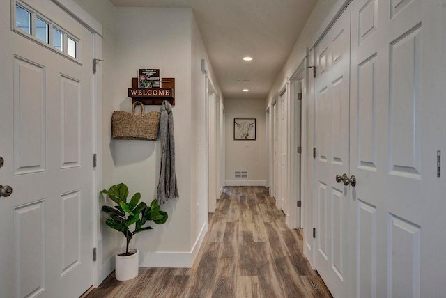 corridor with recessed lighting, wood finished floors, visible vents, and baseboards