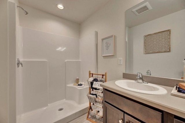 bathroom featuring recessed lighting, visible vents, walk in shower, and vanity