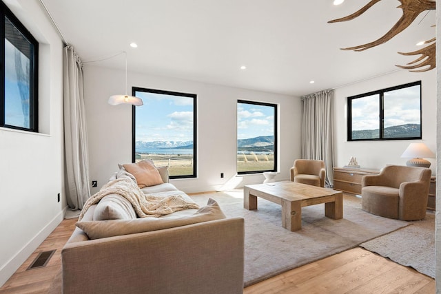 living room featuring visible vents, recessed lighting, baseboards, and light wood-style floors