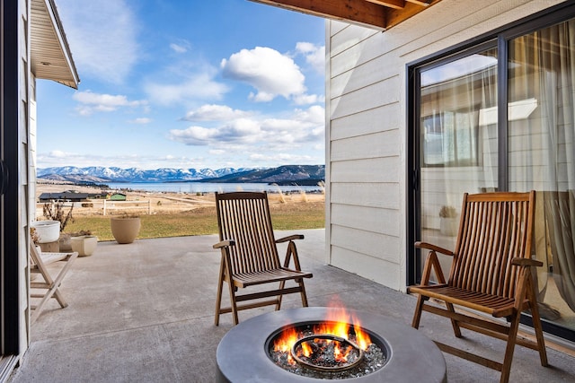 view of patio / terrace featuring a mountain view and a fire pit