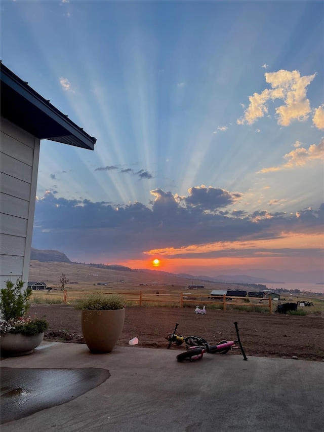 view of yard with a patio area, a rural view, and a mountain view