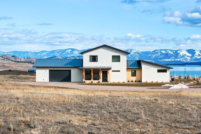 view of front facade with metal roof, a garage, a mountain view, and a standing seam roof