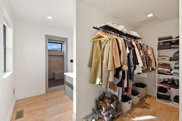 spacious closet featuring attic access, visible vents, and light wood finished floors