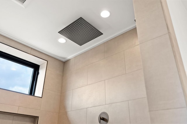 interior details featuring a tile shower, visible vents, and recessed lighting