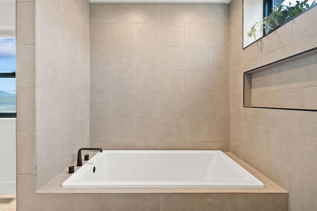 bathroom with tile walls and a bath