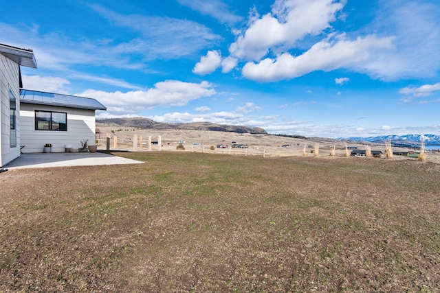 view of yard featuring a patio area and a mountain view