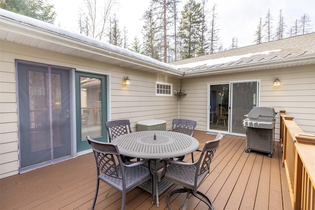 wooden deck featuring outdoor dining space and a grill