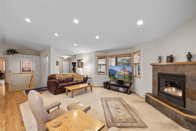 living room with recessed lighting, baseboards, a tile fireplace, and vaulted ceiling