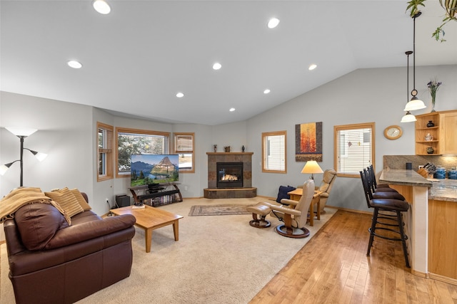 living room featuring recessed lighting, light wood-style floors, baseboards, vaulted ceiling, and a tile fireplace