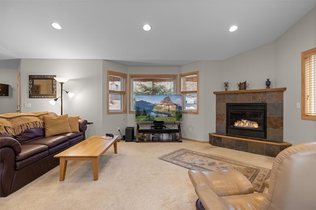 carpeted living area featuring recessed lighting, baseboards, a healthy amount of sunlight, and a tile fireplace