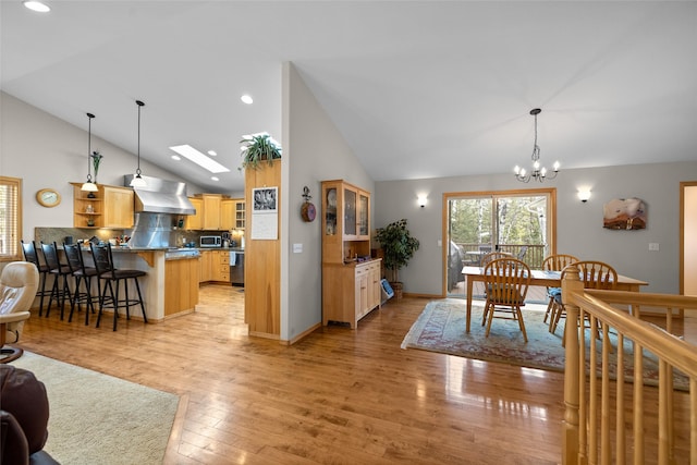 dining area with recessed lighting, light wood-type flooring, high vaulted ceiling, and a chandelier