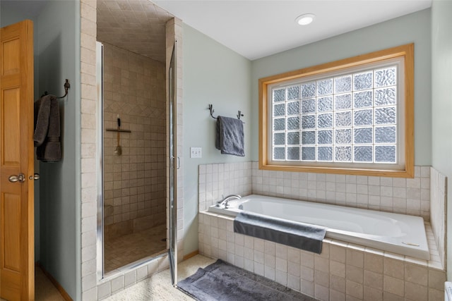 full bath featuring a garden tub, a healthy amount of sunlight, and a stall shower