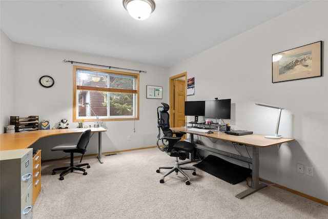 home office with baseboards and light colored carpet