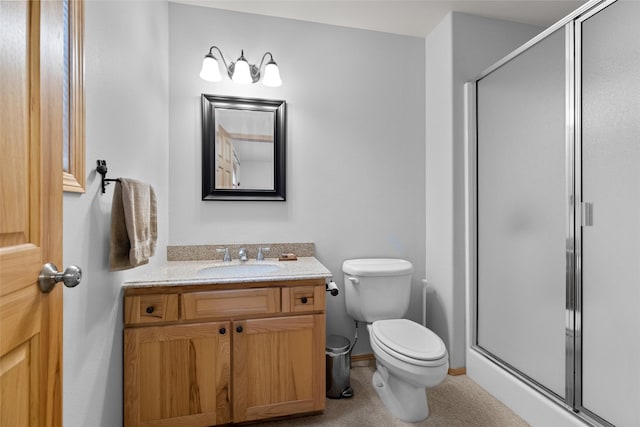 full bath featuring vanity, a shower stall, and toilet