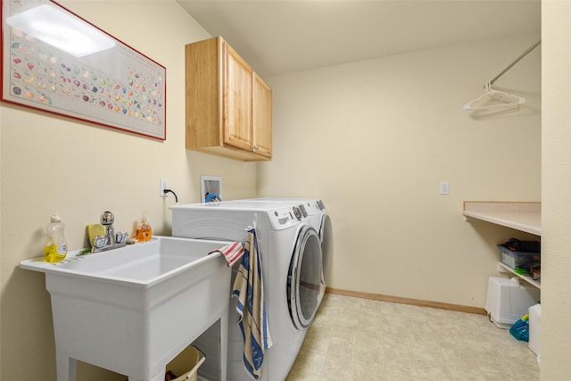 laundry area with a sink, washing machine and dryer, cabinet space, baseboards, and light floors