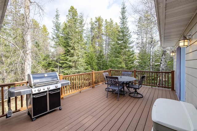 wooden terrace with outdoor dining area and grilling area