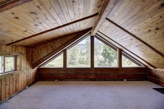 additional living space with lofted ceiling with beams, light colored carpet, wood walls, and wooden ceiling