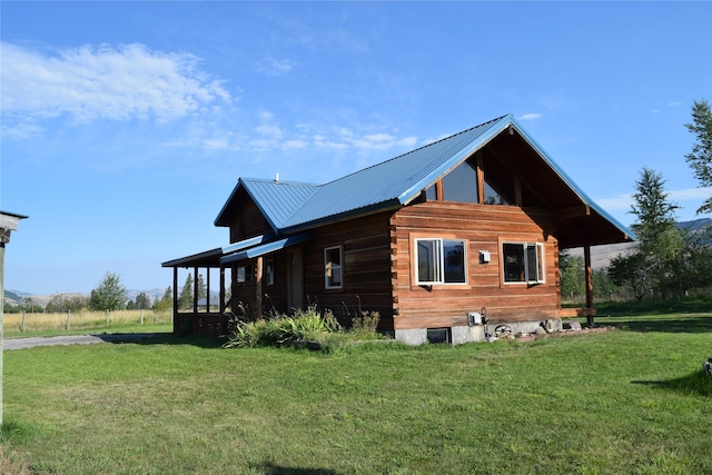 view of property exterior with metal roof and a lawn