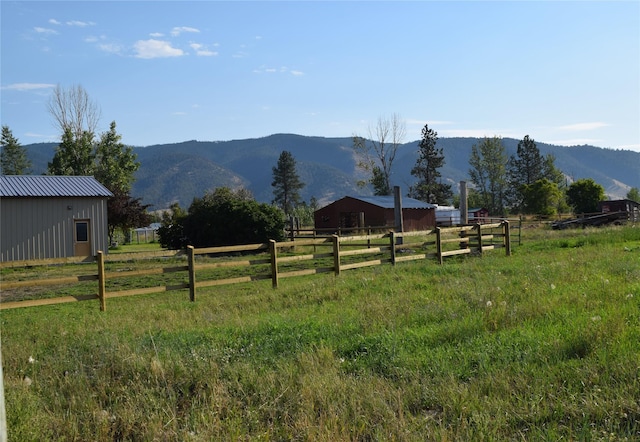 view of yard with an outbuilding, a rural view, and a mountain view