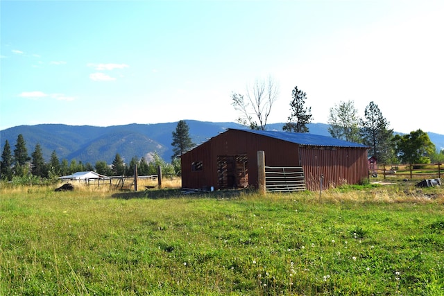 exterior space featuring fence, a rural view, and a mountain view
