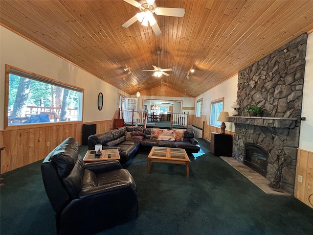 carpeted living area featuring a wainscoted wall, a ceiling fan, wooden walls, wood ceiling, and vaulted ceiling