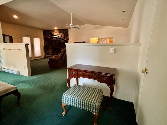 living area with lofted ceiling, carpet floors, a fireplace, a ceiling fan, and a baseboard radiator