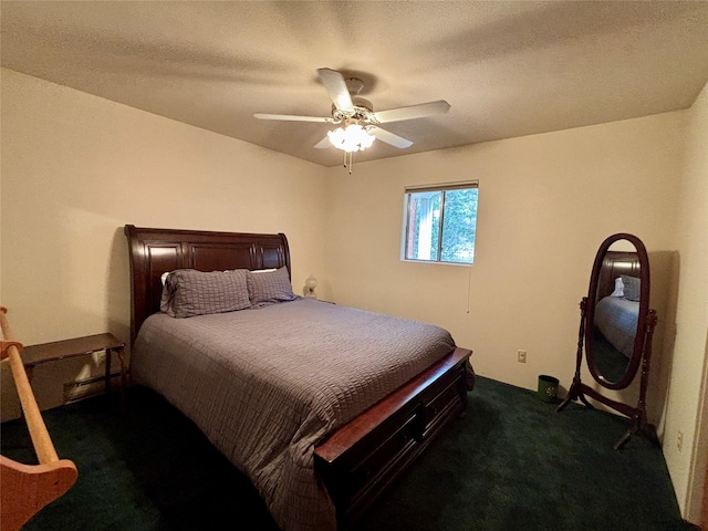 bedroom with a ceiling fan, dark carpet, and a textured ceiling