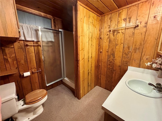 bathroom with wooden walls, toilet, vanity, and a shower with shower door