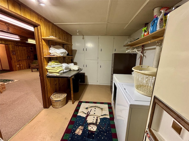 washroom featuring wooden walls, cabinet space, and independent washer and dryer