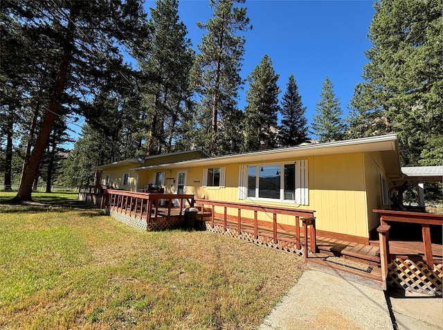 view of front of home featuring a wooden deck and a front yard