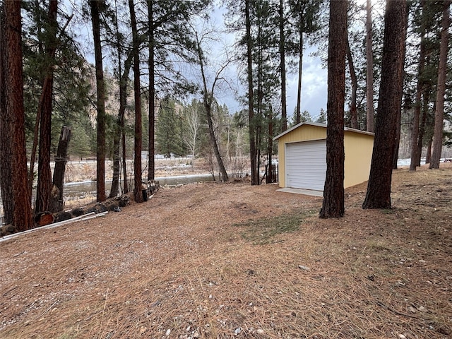 view of yard with a detached garage and an outbuilding