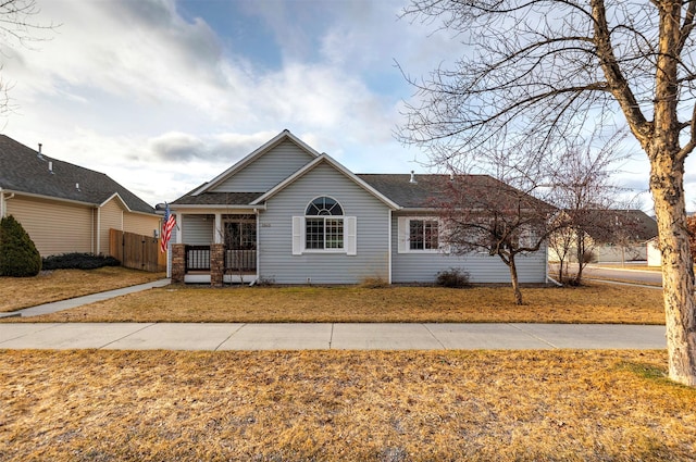 ranch-style home featuring a front lawn and fence