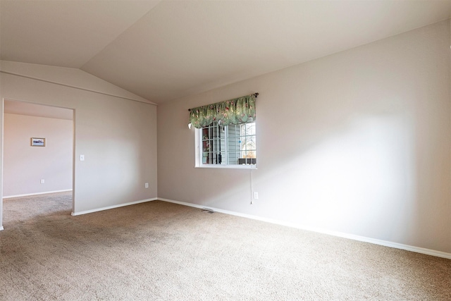 spare room with lofted ceiling, baseboards, and carpet floors