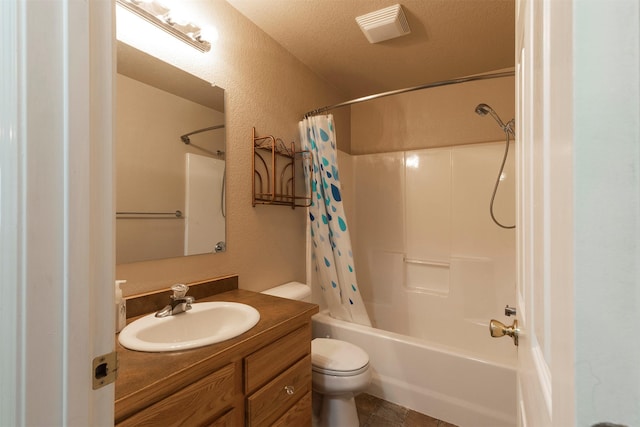 full bathroom with vanity, shower / bath combination with curtain, toilet, and a textured wall