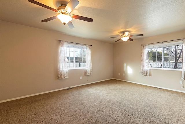 unfurnished room featuring baseboards, carpet floors, a textured ceiling, and a ceiling fan