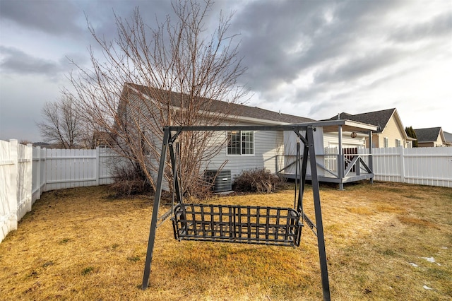 rear view of house with a yard and a fenced backyard