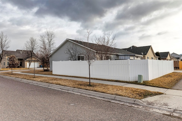 view of property exterior featuring a fenced front yard and a residential view