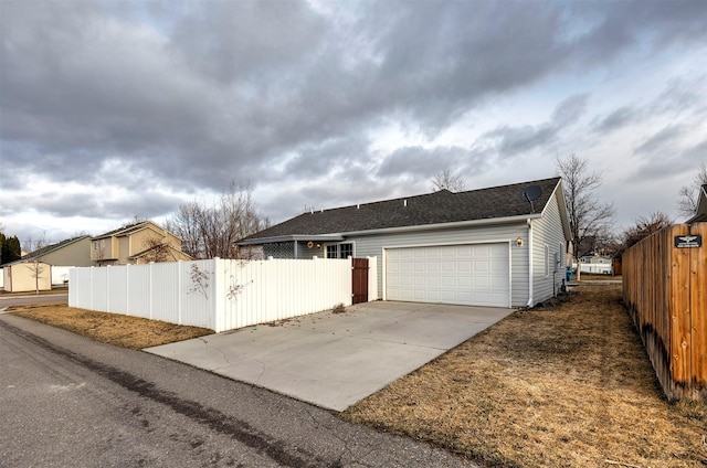 ranch-style house with concrete driveway, a garage, and fence