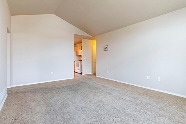 carpeted empty room with baseboards and vaulted ceiling